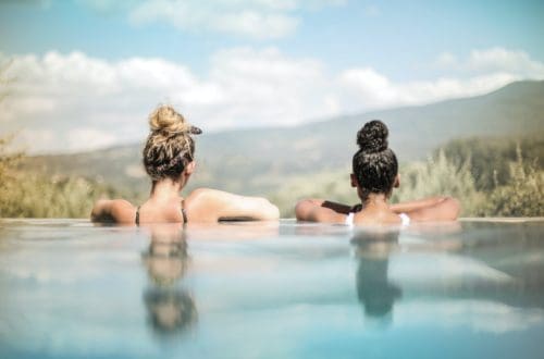 two women sitting side by side in the water